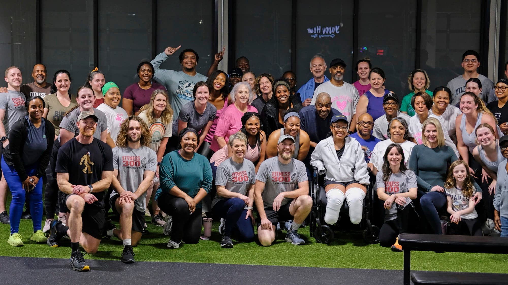 A large group of Fitness 300 members of all ages gathered on the gym turf after a session