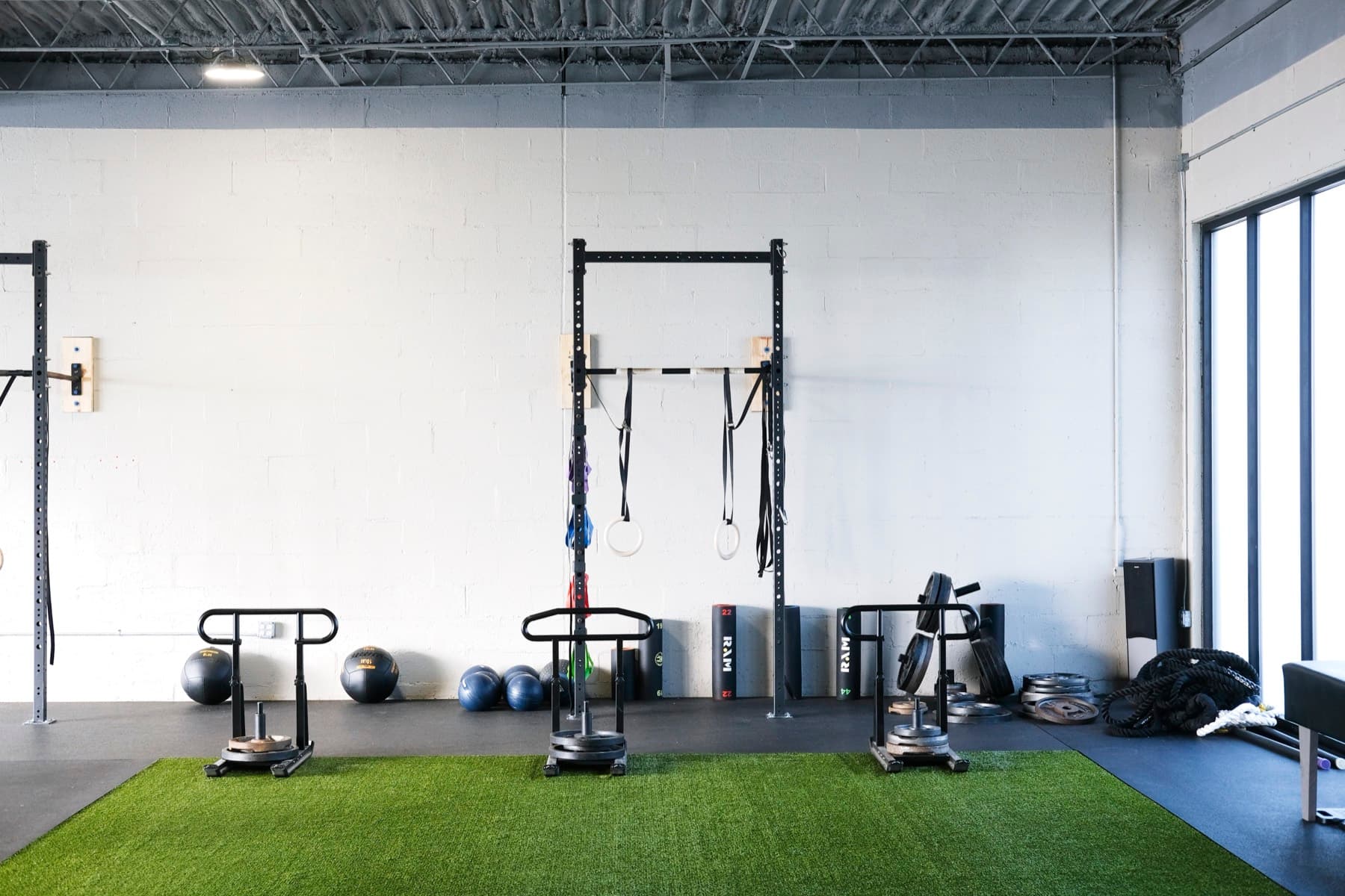 Weighted sleds sitting on the turf lane at Fitness 300