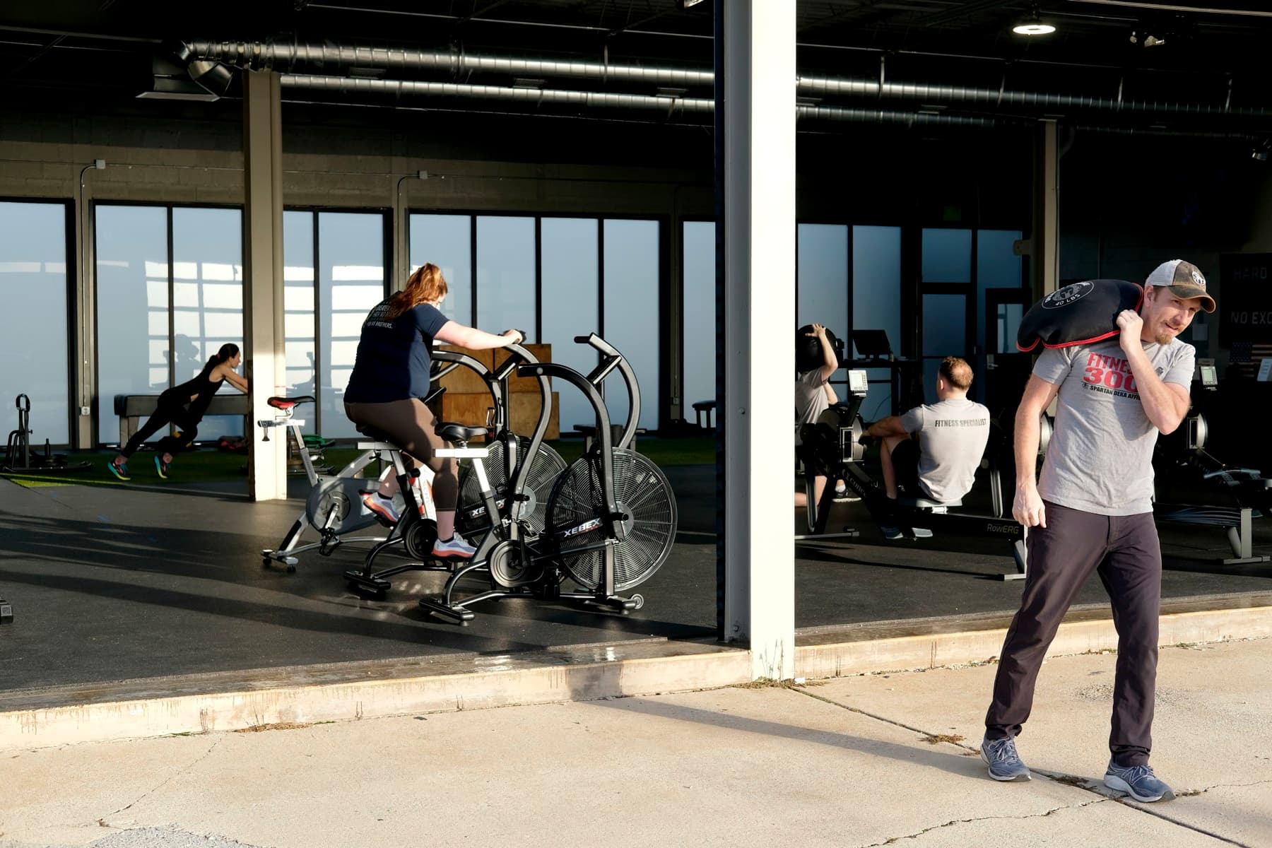 A member pushing a weighted sled outside the Fitness 300 building