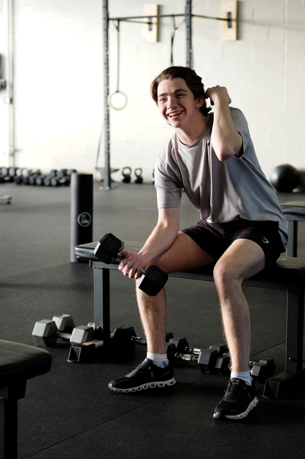 A member pressing dumbbells during a strength session at Fitness 300